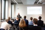 Dr. Detlef Hühnlein, vorne stehend an seinem Laptop mit Beamerbild, zeigt seine Präsentation "Die Standards der EUDI-Wallet und EU-Business-Wallet und ihre Rolle im Deutschland-Stack und EuroStack" 